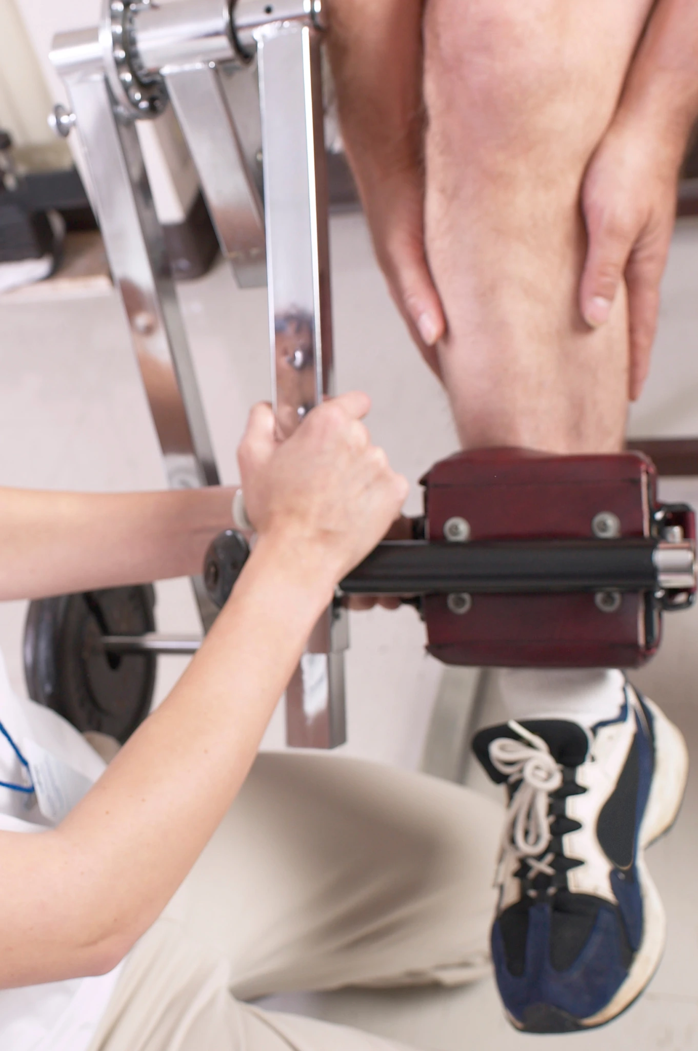 Profissional da saúde realizando reabilitação esportiva no joelho de um paciente, destacando a importância da medicina do esporte na prevenção e recuperação de lesões