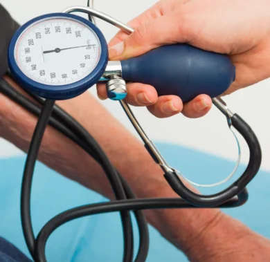 Profissional aferindo a pressão arterial de paciente com esfigmomanômetro manual