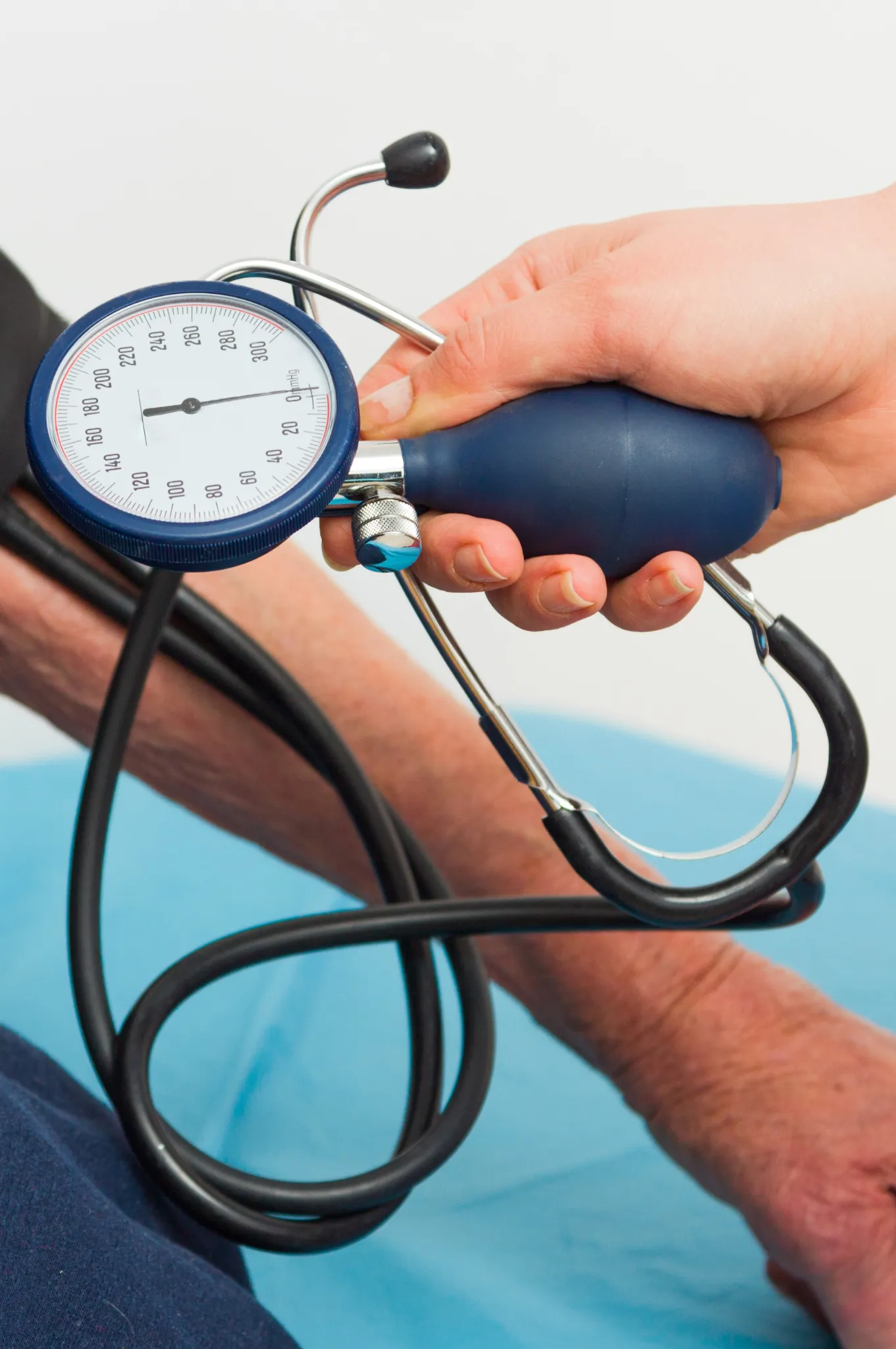 Profissional aferindo a pressão arterial de paciente com esfigmomanômetro manual