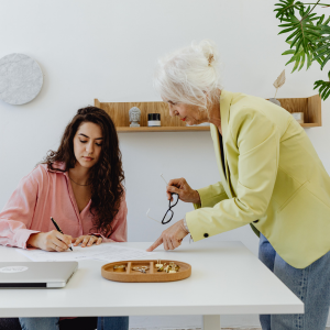 Coordenadora e professora analisando documentação pedagógica interpretativa em reunião de estudo