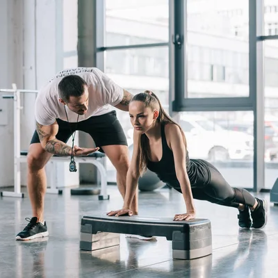[Imagem de profissional de Educação Física orientando exercícios de controle motor]