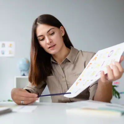 Educadora observando uma criança durante uma atividade pedagógica