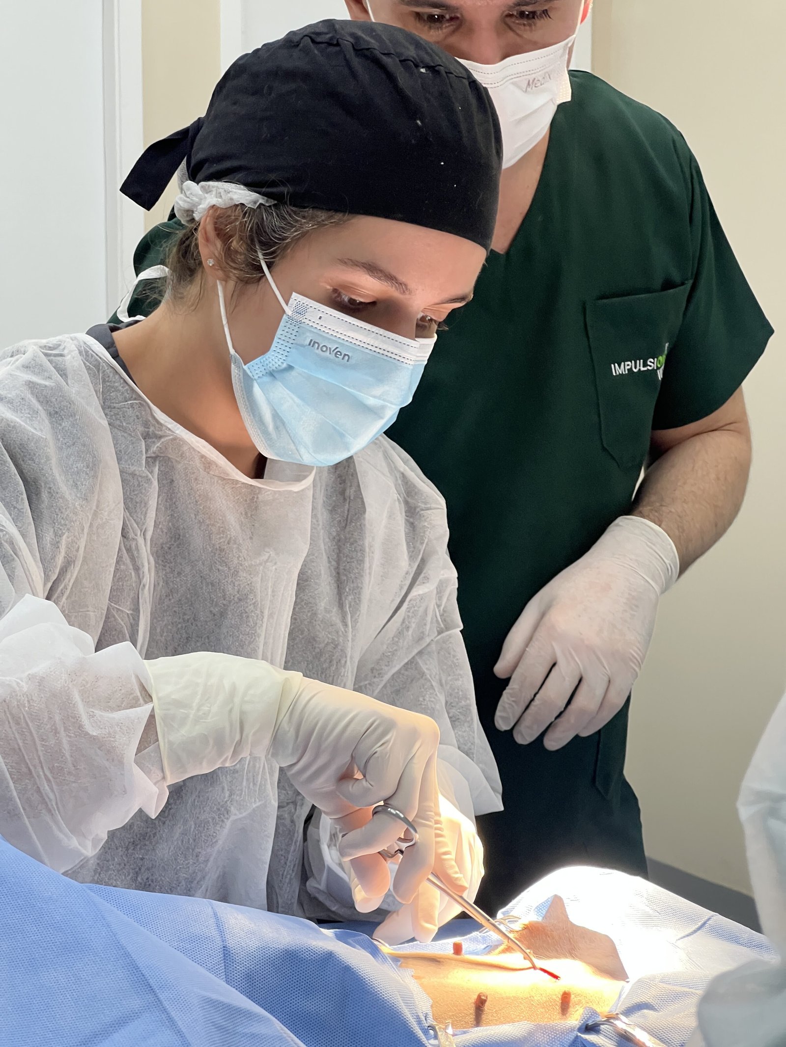 Aluna realiza procedimento cirúrgico acompanhada de perto por um professor