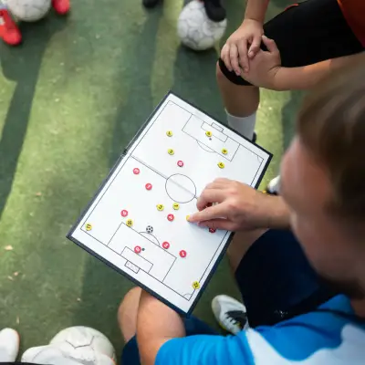 Treinador utilizando prancheta para analisar posicionamento tático no futebol e futsal