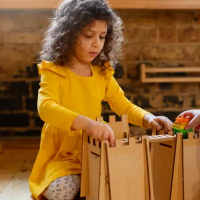 Criança explorando materiais de construção em ambiente de Educação Infantil