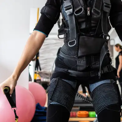 Pessoa realizando treinamento com colete de eletroestimulação muscular em estúdio de EMS