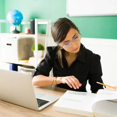 Profissional estudando com notebook e materiais durante formação continuada online